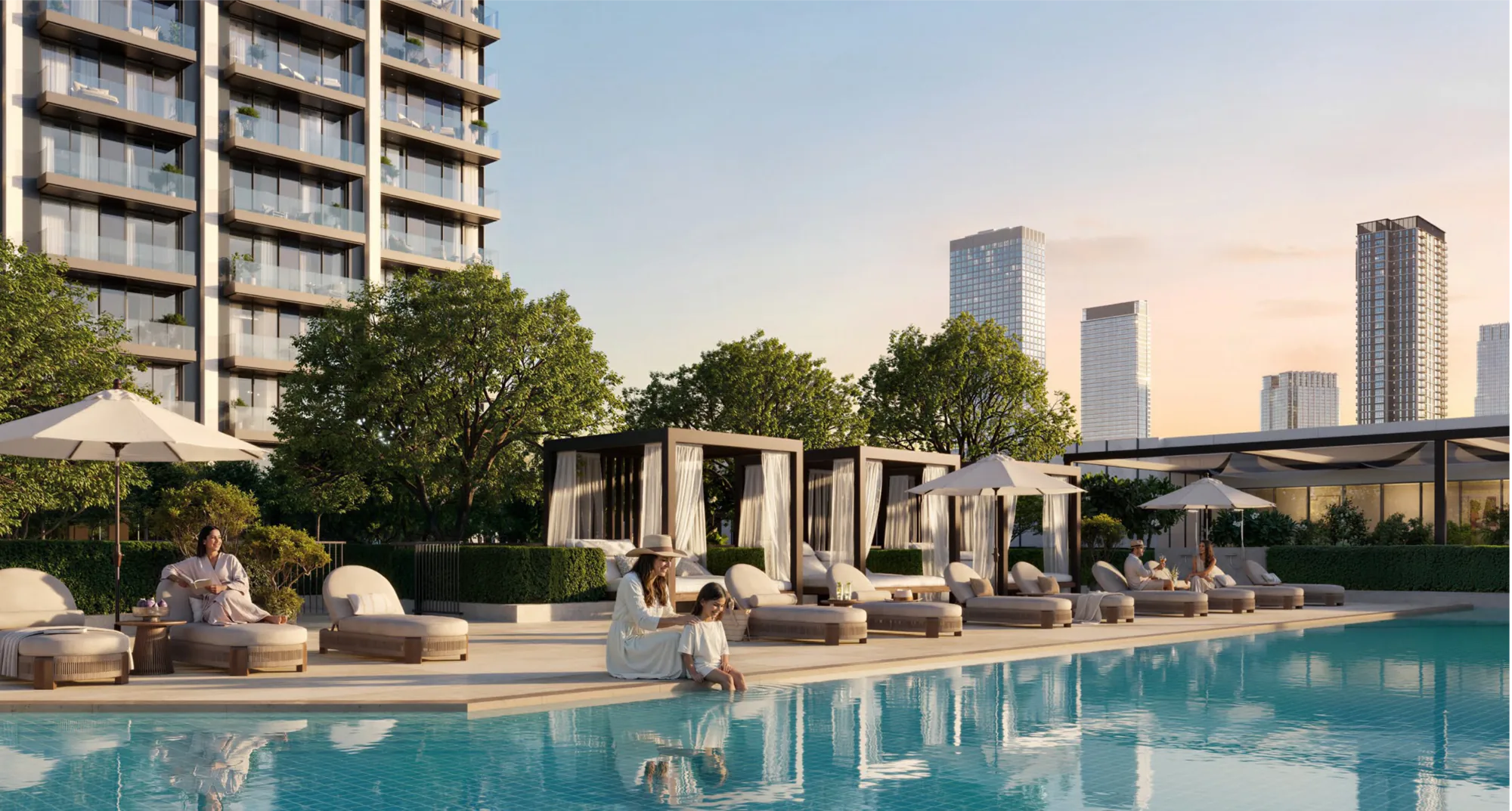 The podium pool deck at Valia at sunset, with cabanas, sun loungers and residents beside the water